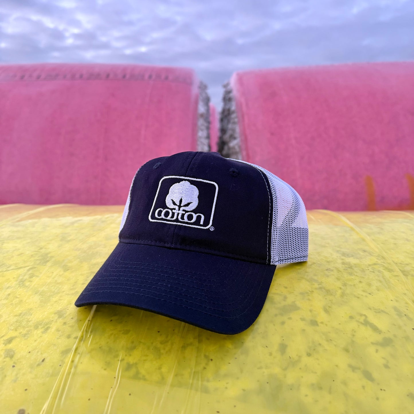 Navy and white mesh back hat with adjustable fit and embroidered Seal of Cotton logo